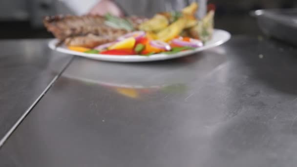 The chef prepares in the restaurant. Grilled rack of lamb with fried potatoes and fresh vegetables. closeup — Stock Video