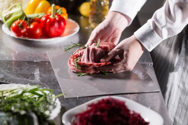 Nadir koyunlar rosemary ile Marine için hazır. Ateşle tavada pişirme. Profesyonel şef yemek Restoran bir mutfak.