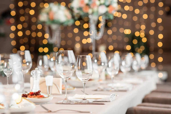 Concéntrate en gafas. Mesa de banquete en el restaurante, la preparación antes del banquete. el trabajo de floristas profesionales . — Foto de Stock