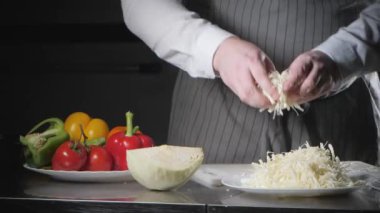 El bıçak kesim taze sebze ile closeup. Genç Şef kesme lahana beyaz kesme pano portre üzerinde. Bir restoran mutfağında yemek