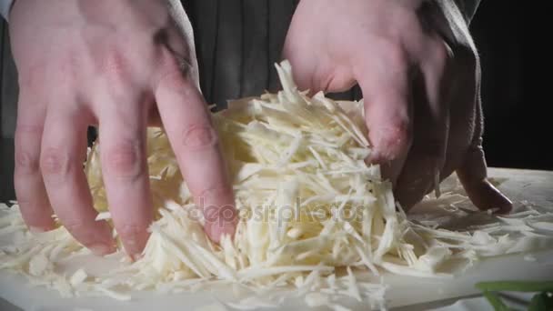 Крупним планом рука ножем розрізає свіжий овоч. Молодий шеф-кухар вирізає капусту на білій обробній дошці крупним планом. Кулінарія на кухні ресторану — стокове відео