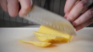 El bıçak kesim taze sebze ile closeup. Genç Şef kesme patateslerin üzerine beyaz kesme pano portre. Bir restoran mutfağında yemek