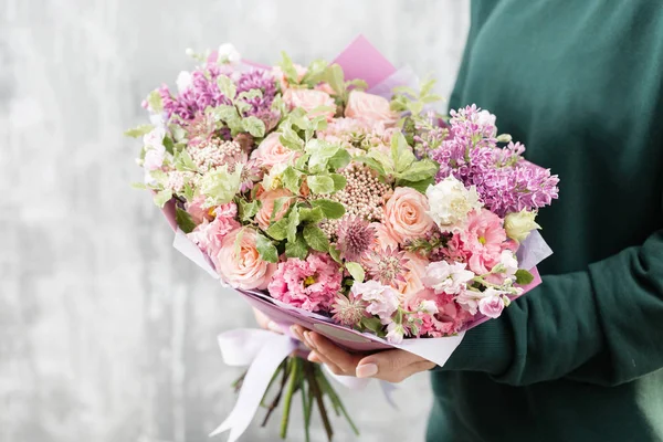 Hermoso ramo de lujo de flores mixtas en mano de mujer. el trabajo de la floristería en una florería. linda chica encantadora — Foto de Stock