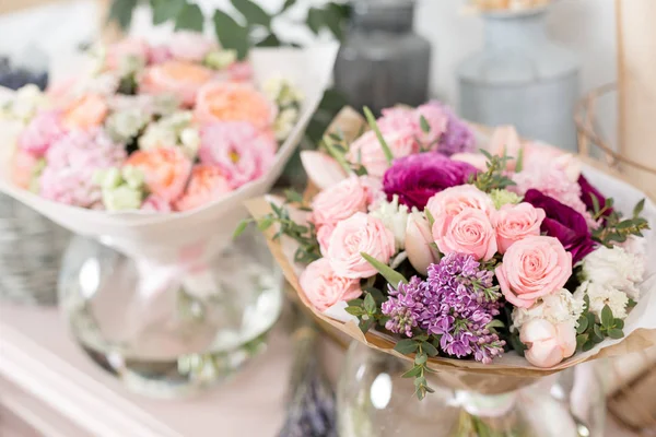 Pocos de hermoso ramo de lujo. Flores mixtas sobre mesa rosa. el trabajo de la floristería en una florería. Boda — Foto de Stock