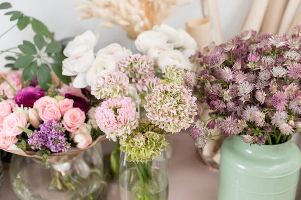 Pocos de hermoso ramo de lujo. Flores mixtas sobre mesa rosa. el trabajo de la floristería en una florería. Boda — Foto de Stock