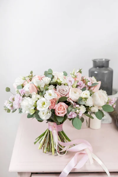 Piękny, luksusowy bukiet z mieszanych kwiatów na stole różowy. Praca w kwiaciarni Kwiaciarnia. Ślub — Zdjęcie stockowe