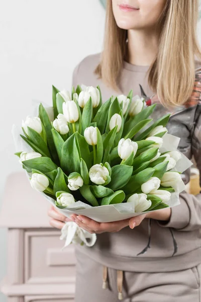 Красивый роскошный букет белых цветов тюльпанов в руке женщины. работа флориста в цветочном магазине. милая милая девушка — стоковое фото