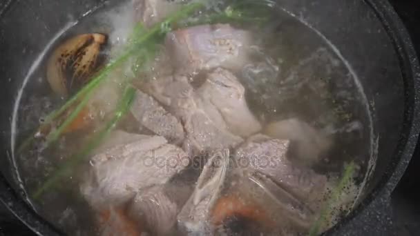 传统的牛肉汤与蔬菜, 骨头和配料的锅, 烹饪食谱。在深色的石头背景上用勺子舀汤。顶部视图 — 图库视频影像