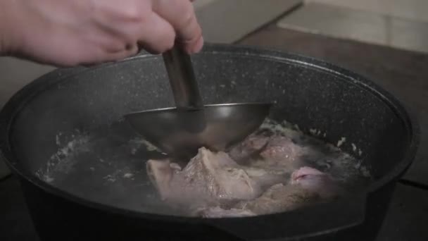 야채, 뼈와 제조 법을 요리, 냄비에 재료는 전통적인 쇠고기 국물 어두운 돌 배경에 국자와 냄비에 수프. 상위 뷰 — 비디오
