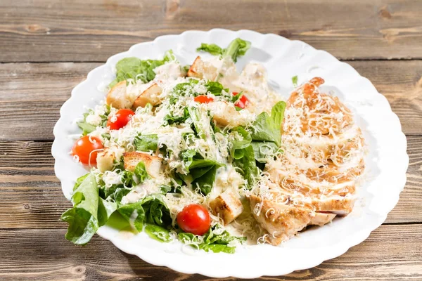 Ensalada César con queso parmesano y croutons. Pechugas de pollo a la parrilla y lechuga romana fresca en plato —  Fotos de Stock