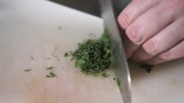El bıçak kesim taze dereotu ile closeup. Genç Şef kesme lahana beyaz kesme pano portre üzerinde. Bir restoran mutfağında yemek