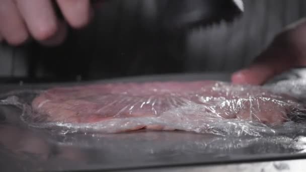 シュニッツェル ウィナー。キッチンのレストランのシェフ。木槌で食肉の軟化。揚げ豚肉の準備 — ストック動画