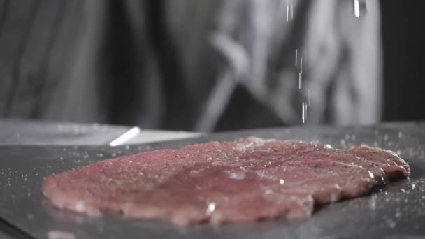 Mets le sel. Schnitzel de Wiener. Porc cru prêt pour la marinade à l'huile. Cuire au feu dans une poêle. Chef professionnel dans une cuisine de restaurant . — Video