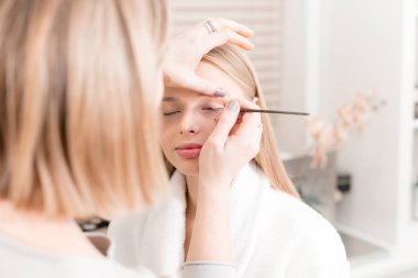 Boya gözler. Makyaj sanatçısı güzel makyaj sarışınlar modeli oluşturma. Güzellik ve Spa merkezi kavramı