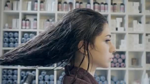 Парикмахер крупным планом делает прическу для молодой женщины в салоне красоты — стоковое видео