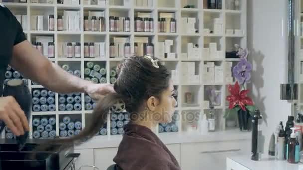 Closeup cabeleireiro homem faz penteado para a jovem mulher no salão de beleza — Vídeo de Stock