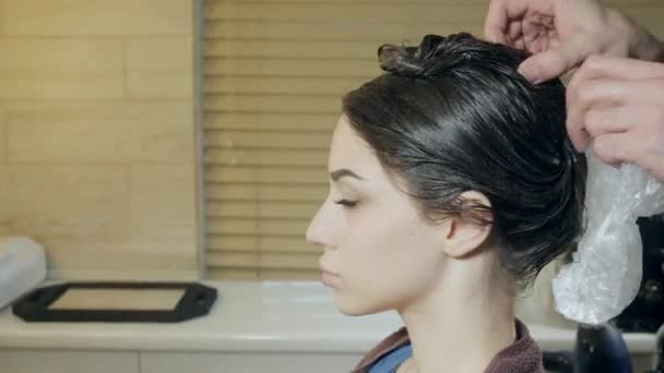 Primer plano peluquero hombre hace peinado para mujer joven en salón de belleza — Vídeo de stock