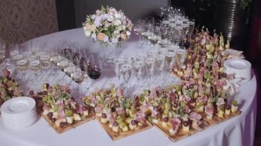 Furshet. En iyi köpüklü beyaz şarap kanepeler ve arka planda antipasti bardak dolu masa. Şampanya kabarcıklar