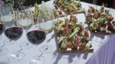 Furshet. En iyi bardak şarap kanepeler ve arka planda antipasti ile dolu masa. Şampanya kabarcıklar