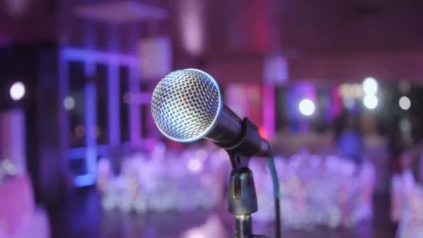 Micrófono sobre la sala de conferencias borrosa abstracta o fondo de banquete de boda — Vídeos de Stock