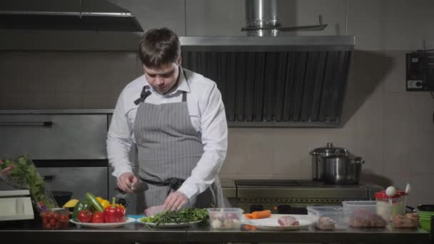 年轻的厨师切辣椒的白色切割板特写。在餐馆厨房做饭 — 图库视频影像