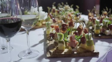 Furshet. En iyi bardak şarap kanepeler ve arka planda antipasti ile dolu masa. Şampanya kabarcıklar