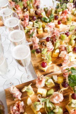 Furshet. En iyi köpüklü beyaz şarap kanepeler ve arka planda antipasti bardak dolu masa. Şampanya kabarcıklar