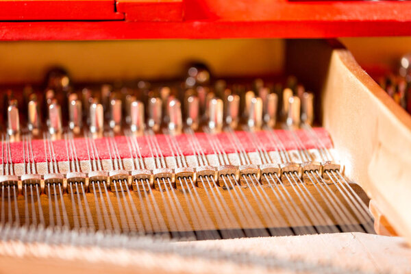 Струны, молотки, глушители и звуковая доска внутри рояля
