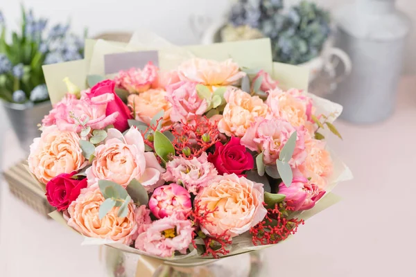 Schöner luxuriöser Strauß gemischter Blumen auf rosa Tisch. die Arbeit der Floristin in einem Blumenladen. — Stockfoto
