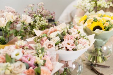 Buketler masada, çiçekçi iş. Farklı çeşitleri taze bahar çiçekleri. Teslimat hizmeti. Çiçek Dükkanı kavramı.