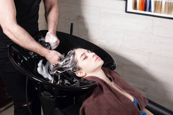 Güzel kız bir güzellik salonunda saçlarını kestirmen önce yıkar. saç Kuaför, genç beyaz kız yıkama. profesyonel şampuan. stilist Kuaför adam — Stok fotoğraf