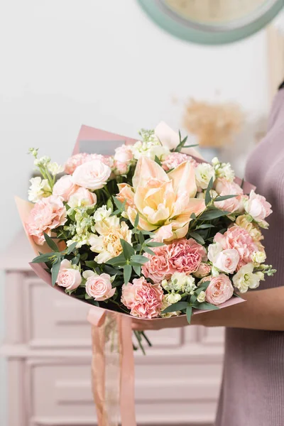 Красивый роскошный букет смешанных цветов в женской руке. работа флориста в цветочном магазине . — стоковое фото