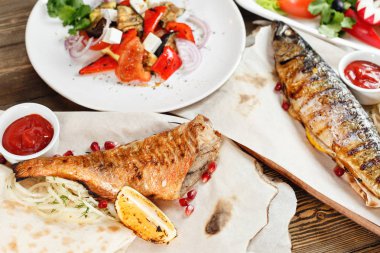 ızgara uskumru ve deniz levreği. Taze sebze salatası. Rustik bir masada ahşap bir gemide hizmet. Barbekü Restoran Menü, bir dizi farklı etler anf balık fotoğrafları