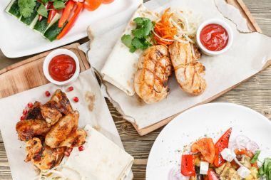 ızgara tavuk göğsü ve kanatlar. Rustik bir masada ahşap bir gemide hizmet. Barbekü Restoran Menü, bir dizi farklı etler Fotoğraflar