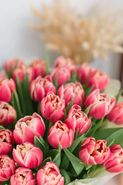 Schöner luxuriöser Strauß rosa Tulpenblüten auf dem Tisch. die Arbeit der Floristin in einem Blumenladen. — Stockfoto