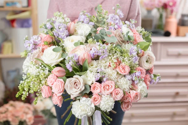 Hermoso ramo de lujo de flores mixtas en mano de mujer. el trabajo de la floristería en una floristería . — Foto de Stock
