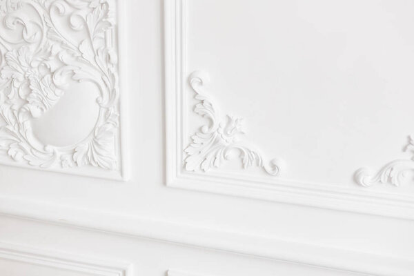 Expensive interior. Stucco elements on light luxury wall. White patterned. Mouldings element from gypsum. Roccoco style