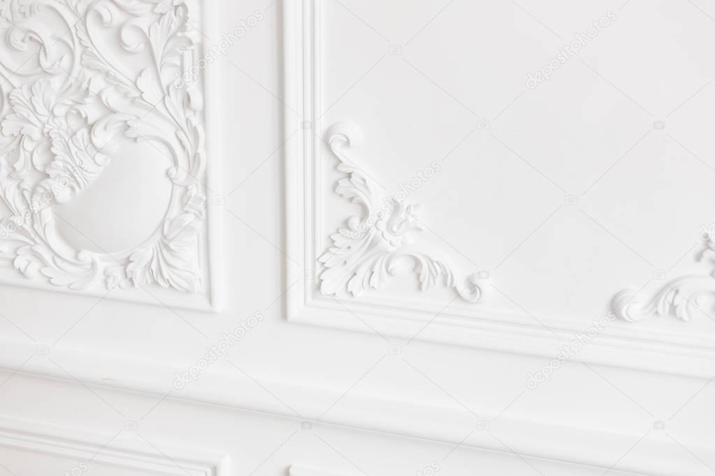Expensive interior. Stucco elements on light luxury wall. White patterned. Mouldings element from gypsum. Roccoco style