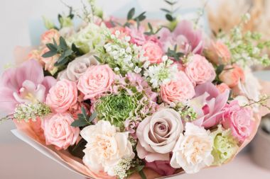 Yakın çekim güzel lüks ahşap masa üzerinde karışık çiçekli buket. Çiçekçi Çiçek dükkanında çalışır. Duvar kağıdı