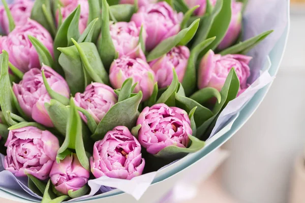 Gros plan. beau bouquet de luxe de fleurs de tulipes lilas sur table. le travail du fleuriste dans un magasin de fleurs . — Photo