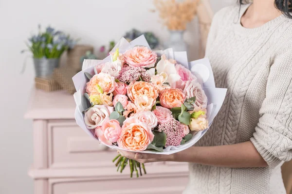 Hermoso ramo de lujo de flores mixtas en mano de mujer. el trabajo de la floristería en una floristería . — Foto de Stock