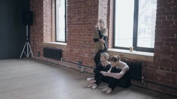 Молоді дівчата балерини. Жінки на репетиції мають чашку чаю або кави — стокове відео