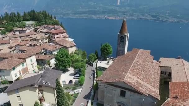 Italien. Kyrkan på berget och gamla stan. Panorama över den underbara Gardasjön omgiven av berg. videoinspelning med drönare — Stockvideo