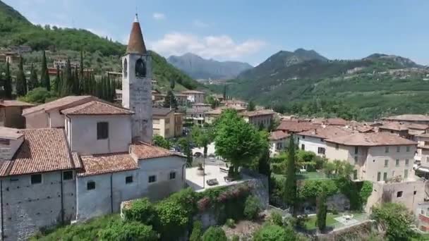 Ιταλία. Η εκκλησία για το βουνό και την παλιά πόλη. Πανόραμα από την πανέμορφη λίμνη Garda περιβάλλεται από βουνά. βίντεο γυρίσματα με drone — Αρχείο Βίντεο