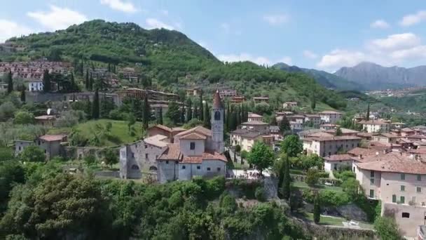 Italië. Kerk op de berg en de oude stad. Panorama van het prachtige Gardameer omgeven door bergen. video schieten met drone — Stockvideo