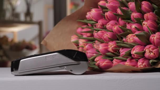 Tulpen in bloemen winkel. Moment van betaling met een credit card via terminal. Kopen en verkopen. Producten diensten. Een gift of een compliment — Stockvideo