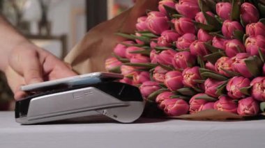 Lale çiçek dükkanında. Temassız ödeme yöntemi. Ödeme terminal aracılığıyla cep telefonu ile an. Satın almak ve satmak. Ürün hizmet. Bir hediye ya da bir iltifat