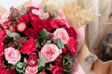 Yakın çekim güzel lüks buket karışık kırmızı ve pembe cam vazo içinde. Çiçekçi Çiçek dükkanında çalışır. Duvar kağıdı