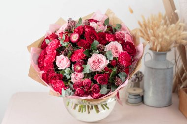 Güzel lüks buket karışık kırmızı ve pembe cam vazo içinde. Çiçekçi Çiçek dükkanında çalışır. Duvar kağıdı