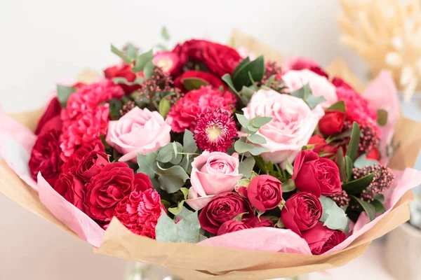 Close-up beautiful luxury bouquet of mixed red and pink flowers in glass vases. the work of the florist at a flower shop. Wallpaper — Stock Photo, Image